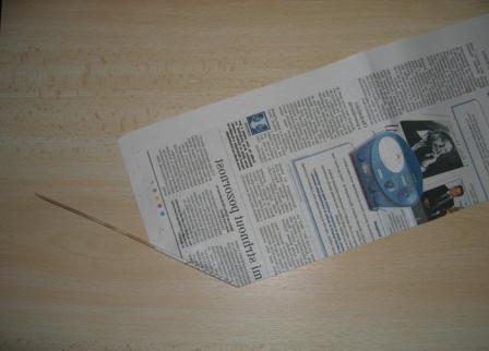 Вокруг вязальной спицы или проволоки обворачиваем полосы так, чтобы спица лежала наискось касательно газеты